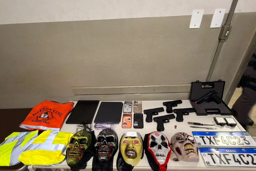 Objetos apreendidos pela Polícia Militar durante abordagem na Avenida Independência, em Piracicaba. Entre os itens estão armas de airsoft, máscaras, facas, placas veiculares, celulares, notebooks e uma munição de calibre .45.